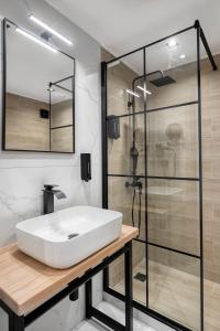 a bathroom with a white sink and a shower at Athenian Heart Suites in Athens +68 photos