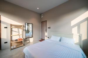a bedroom with a large white bed and a mirror at Kosin House in Bangkok