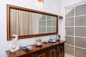 a bathroom with a large mirror and a wooden dresser at Senen Lanka in Kelaniya +33 photos
