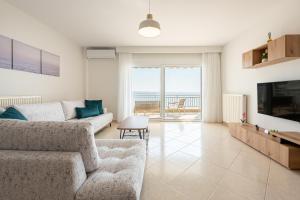 a living room with a couch and a television at Theatre Home Aegean View in Nea Moudania