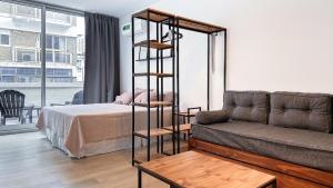 a living room with a bed and a couch at Hermoso Studio Premium en Microcentro in Buenos Aires