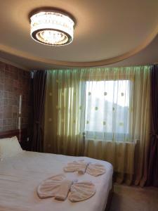 a bedroom with a bed with two towels on it at Пиргуля in General-Toshevo
