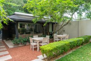 a patio with a table and chairs in a garden at Senen Lanka in Kelaniya