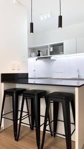 a kitchen with two black stools at a counter at Hermoso Studio Premium en Microcentro in Buenos Aires