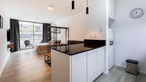 a kitchen and living room with a clock on the wall at Hermoso Studio Premium en Microcentro in Buenos Aires