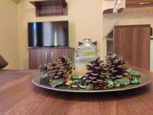 a plate with pine cones and a glass jar on a table at Пиргуля in General-Toshevo