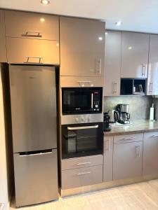 a kitchen with a stainless steel refrigerator and microwave at Maison du Lavoir Disneyland in Bailly-Romainvilliers