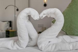 a pair of towels forming a heart on a bed at Urban Heights - 2 Bed Apartment - Short Stays UK Ltd in Exeter