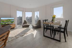 a living room with a dining table and a tv at Urban Heights - 2 Bed Apartment - Short Stays UK Ltd in Exeter