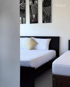 a bedroom with two beds and three pictures of zebras at Bay Beach Hotel Nilaveli in Kumpurupiddi