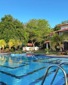a swimming pool with blue water and trees at Bay Beach Hotel Nilaveli in Kumpurupiddi