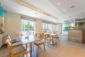 a restaurant with tables and chairs and a screen at Villa Cannes Jastarnia in Jastarnia