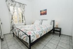 a bedroom with a bed and a window at Ionian Luxury Apartments in Perama