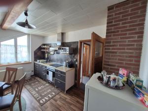 a kitchen with a stove and a brick wall at Unterkunft Julian in Waghäusel