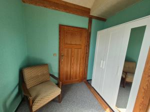 a chair and a door in a room with green walls at Unterkunft Julian in Waghäusel