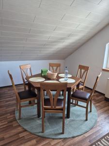a dining room with a wooden table and chairs at Unterkunft Julian in Waghäusel +4 photos