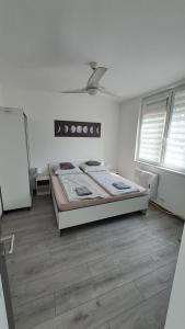 a bedroom with a bed in the middle of the room at Grey Harmony Apartman in Debrecen