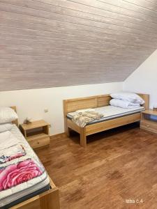 two beds in a room with wooden floors at Slnečný domček Sučany in Sučany