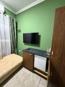 a small room with a bed and a flat screen tv at 13 Daily apartments in Tirana