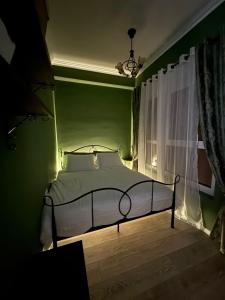 a bed in a green bedroom with a window at 13 Daily apartments in Tirana