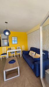 a living room with a blue couch and a table at Primera Linea de playa in Almería
