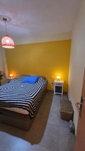 a bedroom with a bed and a yellow wall at Primera Linea de playa in Almería