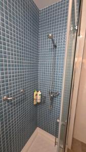 a bathroom with a shower with blue tiled walls at Primera Linea de playa in Almería +31 photos