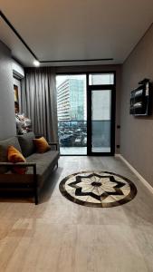 a living room with a couch and a rug at Hostly, New Boulevard Prime Stay in Batumi