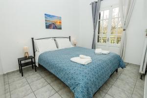 a bedroom with a bed with two towels on it at Ionian Luxury Apartments in Perama