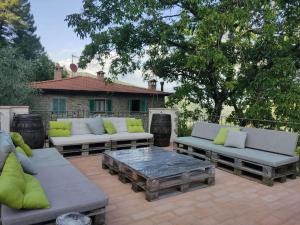 a patio with couches and a table and a house at Agricampeggio Boschetto Gioioso in Barbiano