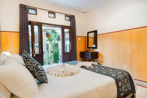 a bedroom with a large bed with a large window at Meliora bali villa in Ubud