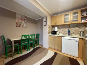 a small kitchen with green chairs and a table at Apartmán Stráne in Martin
