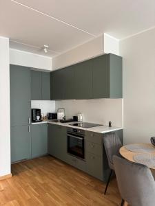 a kitchen with green cabinets and a table at Loo Apartment in Loo