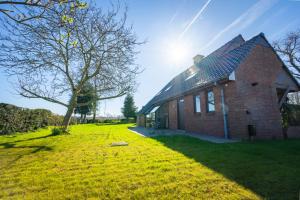 a brick house with a tree and a grass yard at t' Zwaluwnestje in Zedelgem