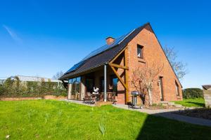 a large red brick house with a black roof at t' Zwaluwnestje in Zedelgem