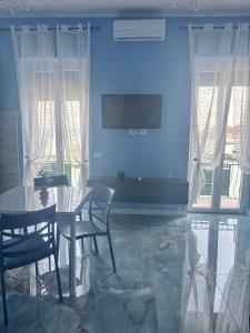 a dining room with a table and chairs and a television at Tower casa vacanze 2 in Anzio