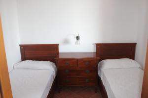 a bedroom with two beds and a wooden dresser at Residence Hotel Torresilvana in Vieste