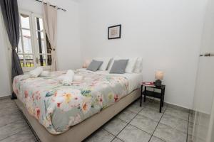 a bedroom with a large bed with a floral blanket at Ionian Luxury Apartments in Perama