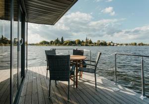 a wooden deck with a table and chairs on a boat at Uroczysko Warta in Uniejow