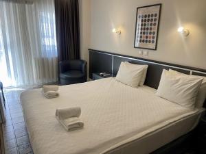 ein Hotelzimmer mit einem großen Bett mit zwei Stühlen in der Unterkunft Hotel Balca in Izmir