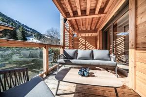 a porch with a couch and a table at Apartment Montami, Châtel - by EMERALD STAY in Châtel