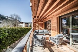 a deck with chairs and a couch on a house at Apartment Montami, Châtel - by EMERALD STAY in Châtel