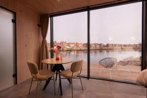 a dining room with a table and chairs and a large window at HANNAH Mirror Tiny House in Den Bosch