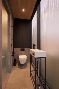 a bathroom with a white toilet and a sink at HANNAH Mirror Tiny House in Den Bosch +29 photos