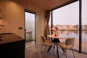 a kitchen with a table and chairs and a large window at HANNAH Mirror Tiny House in Den Bosch