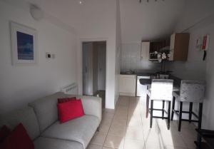 a living room with a couch and a kitchen at Stable Cottage, Whitebridge Farm in Shaftesbury