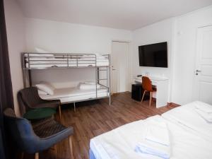 a bedroom with a bunk bed and a desk at Hotel Aveny in Gävle