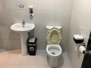 a bathroom with a toilet and a sink at Libhu Hill Resort and Sports Complex in Maasin