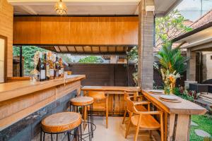 an outdoor bar with wooden tables and chairs at Meliora bali villa in Ubud