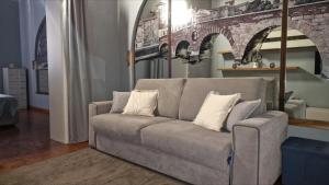 a living room with a couch and a brick wall at Residence Via Duomo in Verona